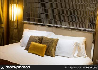 Pillows on a bed in a hotel, brown and yellow.