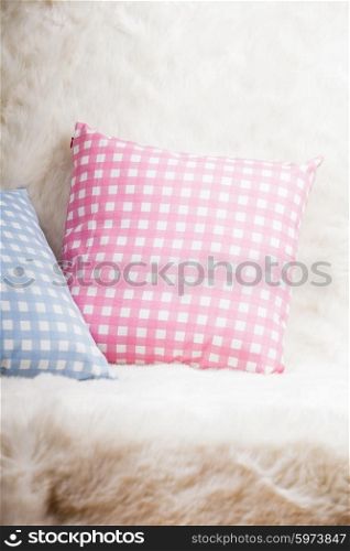 Pillows on the sofa with white fur. Pillows on the sofa