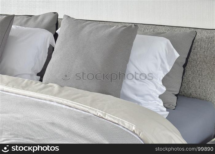 Pillows setting on bed with gray color scheme bedding