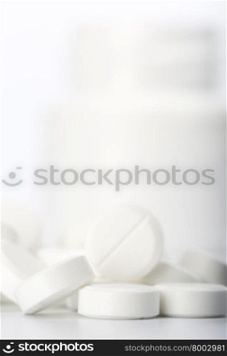 Pills and pill bottle . Close up tablet and pill bottle on white background