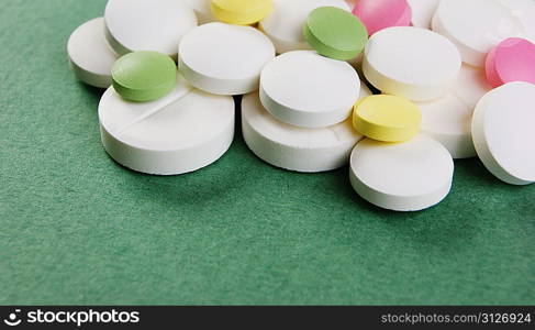 Pills and tablets on a green background