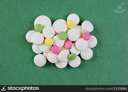 Pills and tablets on a green background