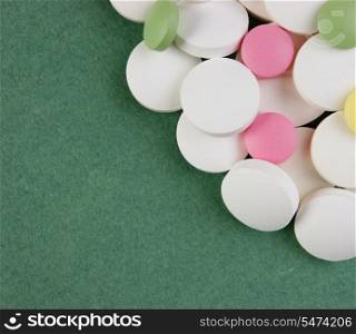 Pills and tablets on a green background