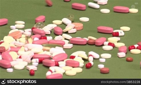 Pills being spilled over green background