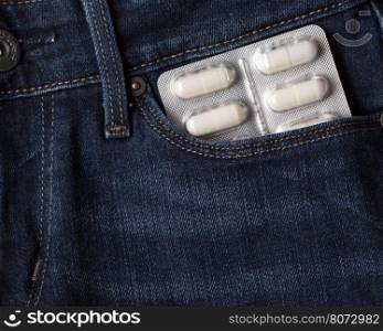 Pills blister pack of white capsules in jeans pocket. Blister pack of pills in jeans pocket