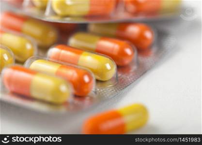 Pills capsule in plastic strip on white. Antibiotics, vitamins, painkiller.