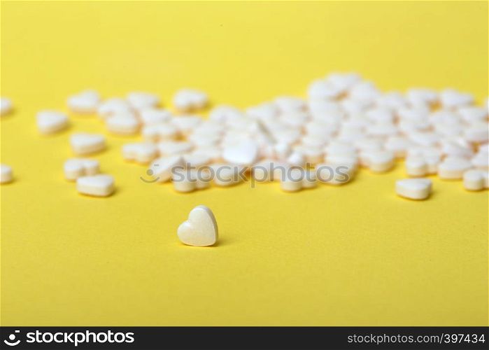 pills in the form of hearts on a yellow background