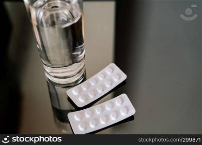 pills medicine tablets and glass of water, healthcare and medicine recovery concept