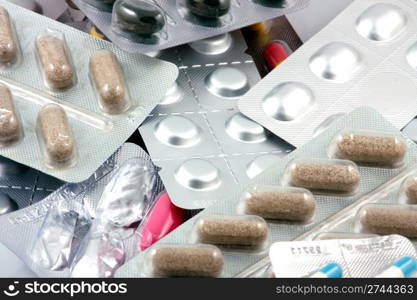 Pills of many shapes and colors grouped together