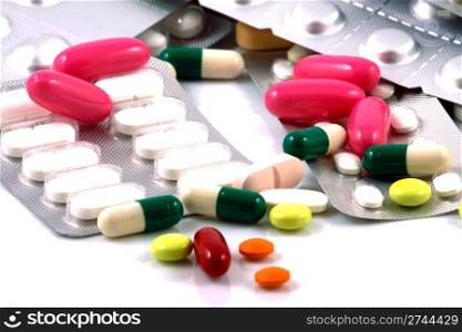 Pills of many shapes and colors grouped together