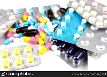 Pills of many shapes and colors grouped together.