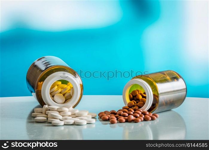 Pills on a table with two glasses in blue light