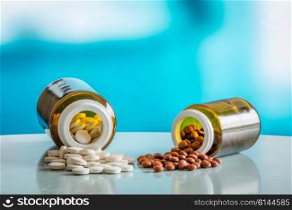 Pills on a table with two glasses in blue light