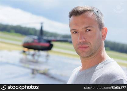 pilot on airfield with helicopter