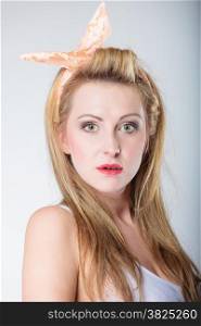 pin up beautiful blonde fashion girl in hairband retro styling, studio shot gray background