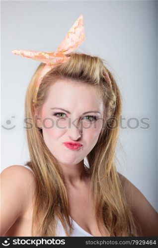 pin up funny blonde fashion girl in hairband retro styling, woman making silly face, having fun, gray background