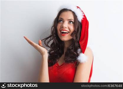 Pin-up Santa girl. Pretty Pin-up style Santa girl in red hat showing white background