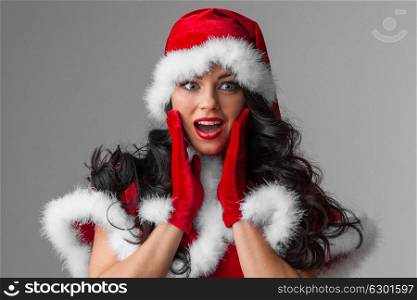 Pin-up Santa girl. Pretty surprised Pin-up style Santa girl in red hat