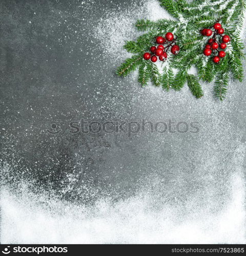 Pine branches with red berries in snow. Christmas holidays background. Vintage style toned picture