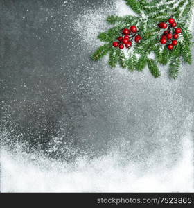 Pine branches with red berries in snow. Christmas holidays background. Vintage style toned picture