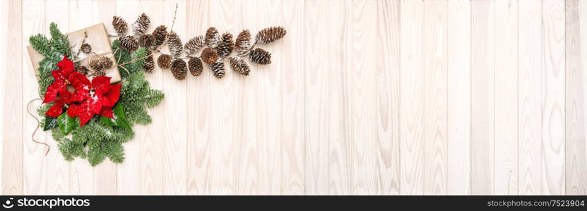 Pine branches with red flowers poinsettia on wooden background. Christmas decoration