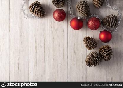 Pine cones and red christmas balls for christmas decoration on rustic white wooden background. Top view. Copy space for your text