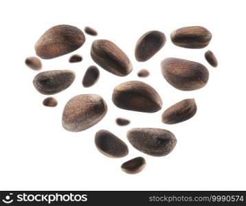 Pine nuts in the shape of a heart on a white background.. Pine nuts in the shape of a heart on a white background