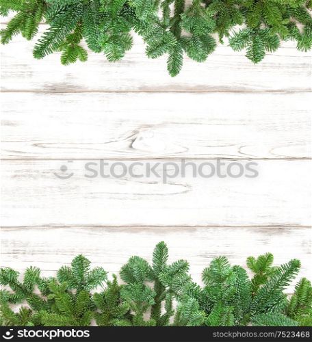 Pine tree twigs on wooden background. Winter holidays decoration