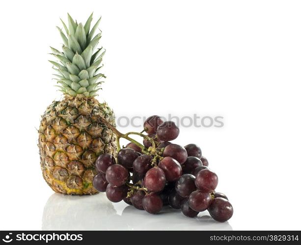 pineaple and red grapes isolated on white