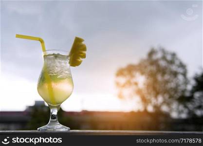Pineapple cocktail and pineapple slices on the sunset. summer concepts.