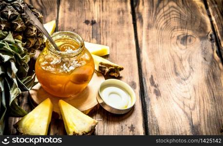 Pineapple jam with pieces. On a wooden table.. Pineapple jam with pieces.