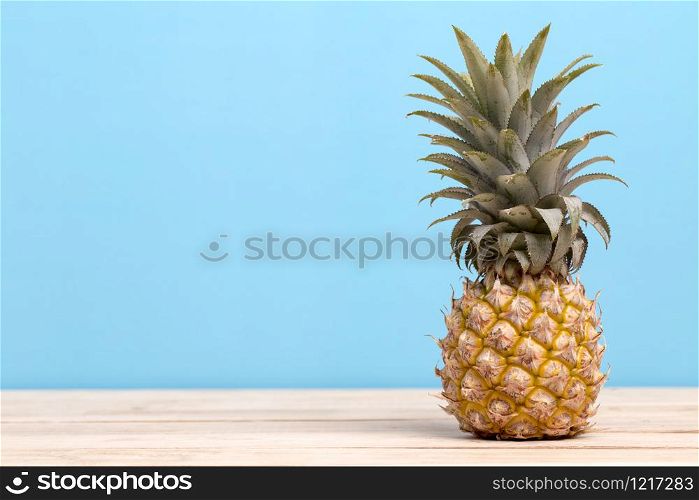 Pineapple on a table isolated on blue background