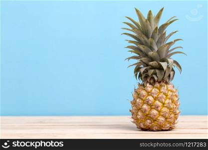 Pineapple on a table isolated on blue background