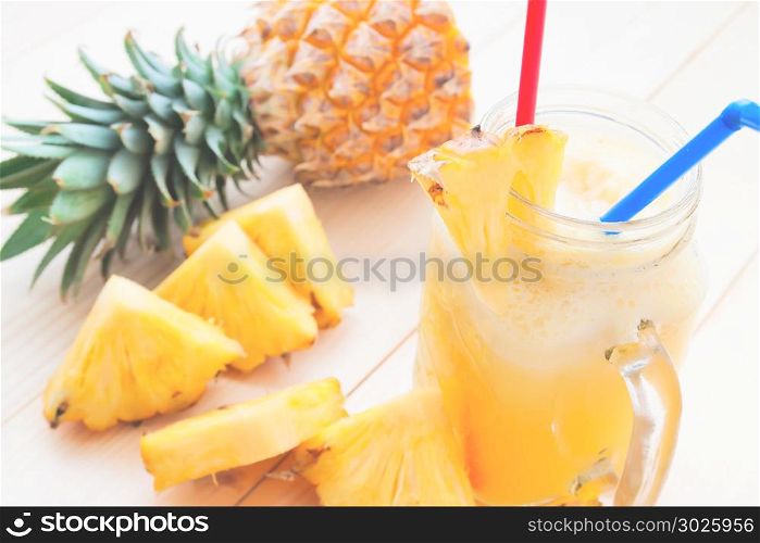 Pineapple smoothie and fresh pineapple slice on wooden table, Tropical drink, Summer holiday