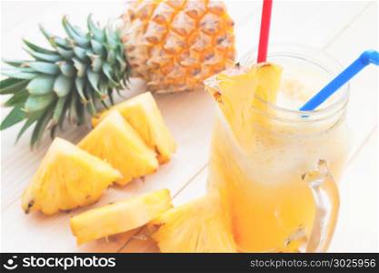 Pineapple smoothie and fresh pineapple slice on wooden table, Tropical drink, Summer holiday