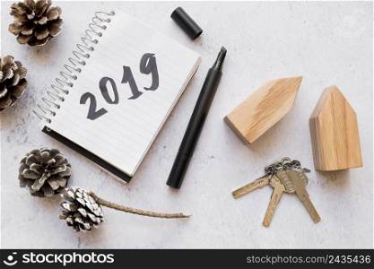 pinecones keys wooden house blocks 2019 written notepad with felt tip pen white textured surface