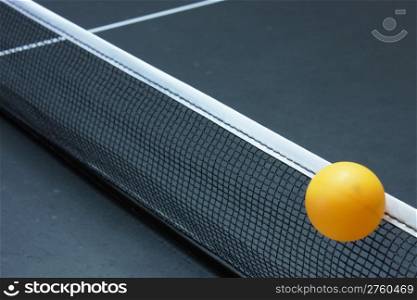 Ping pong ball going over the net while playing ping pong