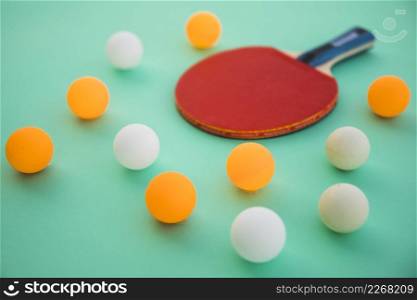 ping pong balls wooden racket turquoise background