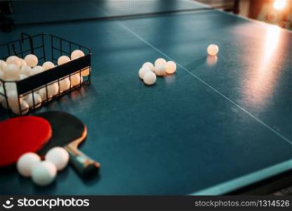 Ping pong table, rackets and basket with balls closeup, game equipment. Tabletennis concept