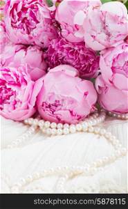 pink a peony on lace. fresh pink peonies with pearls on white lace background