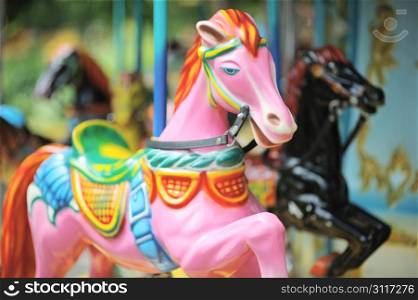 Pink and black horses on the carousel in City Park