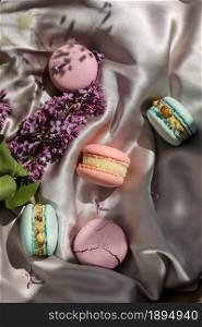pink and mint french macaroons or macarons cookies and a lilac flowers on a cloth background. Natural fruit and berry flavors, creamy stuffing for valentines mother day easter with love food.. pink and mint french macaroons or macarons cookies and a lilac flowers on a cloth background. Natural fruit and berry flavors, creamy stuffing for valentines mother day easter with love food