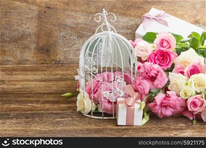 pink and white flowers. bunch of pink and white fresh roses and eustoma flowers with gift box on wooden background