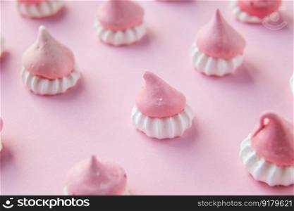 Pink and white meringues stand on a pink background, background picture. Scattered pink and white decor for baking, meringue , a place to advertise a pastry chef