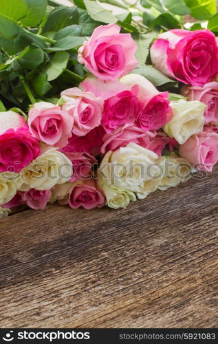 pink and white roses . fresh pink and white roses border on wooden background