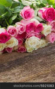 pink and white roses . fresh pink and white roses border on wooden background