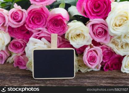 pink and white roses . fresh pink and white roses with empty blackboard