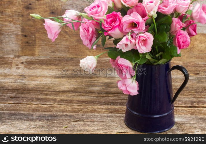pink and white roses . fresh pink roses and eustoma flowers in blue pot on wooden table