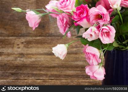 pink and white roses . fresh pink roses and eustoma flowers on wooden table