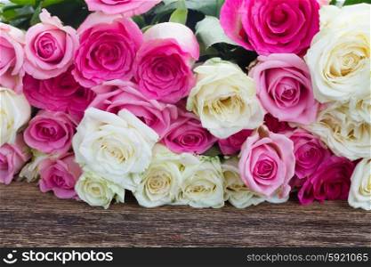 pink and white roses . pile of fresh pink and white roses on wooden table